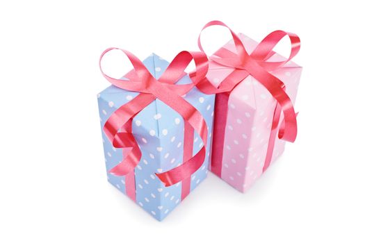 Gifts for him and her. Close-up shot of two gifts, blue for a boy and pink for a girl, isolated on white background.