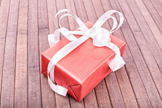 Close-up shot of a gift box on a wooden background.