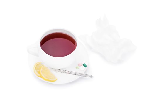 Cup of tea with pills, lemon slices, a thermometer and wrinkled tissue paper, isolated on white background.
