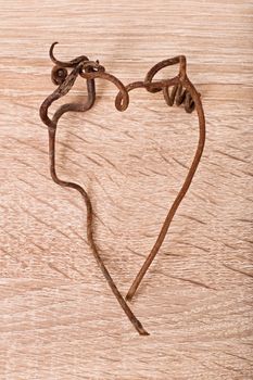 Withered heart. Heart shape made of vines on textured wooden background.