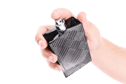 Close up shot of a male hand holding an unlabelled black perfume bottle, isolated on white background.