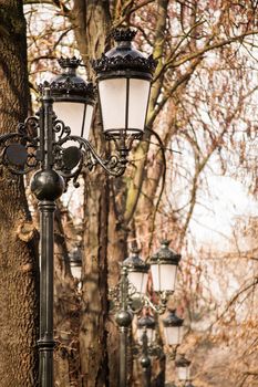 Close up shot of an array of old fashioned lantern street lights in a park.