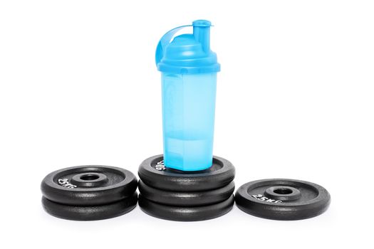 Protein shaker on a pedestal of weight plates, isolated on a white background. Look after your health and well being.