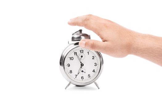 Hand reaching out to turn off the alarm from the alarm clock, isolated on white background.