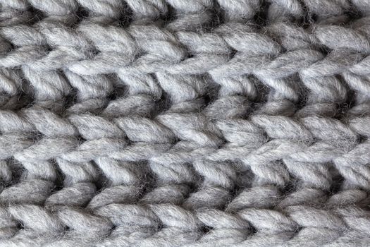 Knitted woolen textured surface, macro. Soft grey merino wool pattern backdrop, closeup. Autumn and winter flat lay. Scandinavian minimal style.