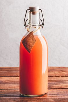 Bottle of grapefruit juice on wooden surface