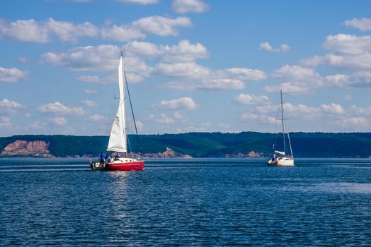 Two Sailing Boats, White and Red, on the River.