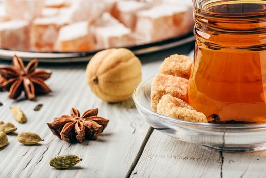 Asian tea in armudu glass with Rahat Lokum and different spices over wooden surface