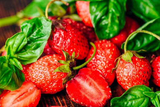 Whole and Sliced Strawberries and Basil Leaves Background.