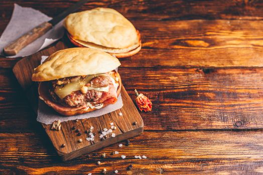 Cheeseburger with Beef Patty on Wooden Background and Copy Space.