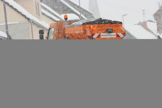 Winter service vehicle in use in heavy snow-fall  Winterdienstfahrzeug im Einsatz bei starkem Schneefall