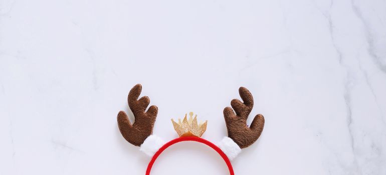 Fancy headband with reindeer antler decorative shape for christmas party and celebration on white marble background, banner style for text