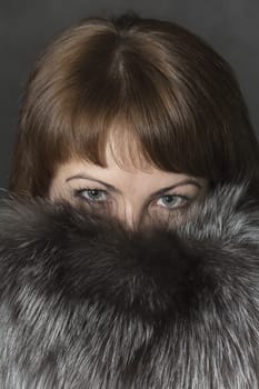 Expressive eyes of a young girl in natural fur collar