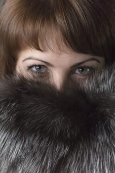 Expressive eyes of a young girl in natural fur collar