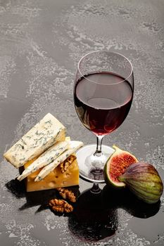 Glass of wine, cheese and fig on a glass background