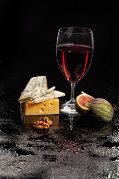 Glass of wine, cheese and fig on a glass background
