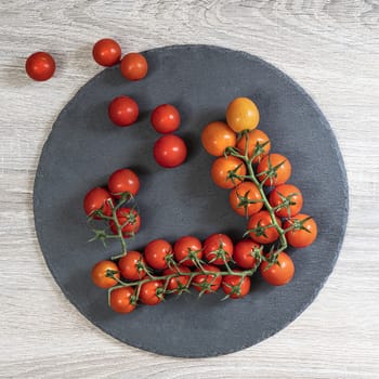 Some tomatoes on a black Ssone dish