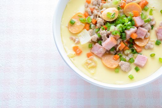 Steamed egg custard cuisine in a white bowl with minced pork, sausage and bacon.  Or Only with egg, water, salt and some sesame oil, you can make this super smooth custard at home. 
