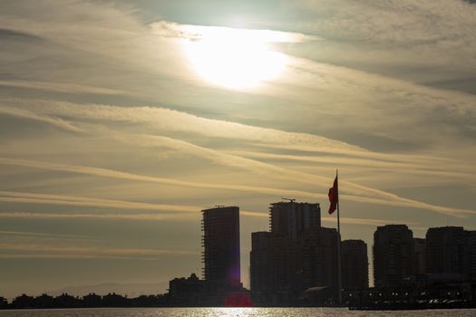 a cityscape shoot with low shutter speed - yellow sun is shining inside clouds. photo has taken at izmir/turkey.