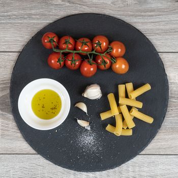 the ingredients for the preparation of a pasta with tomato, garlic and olive oil