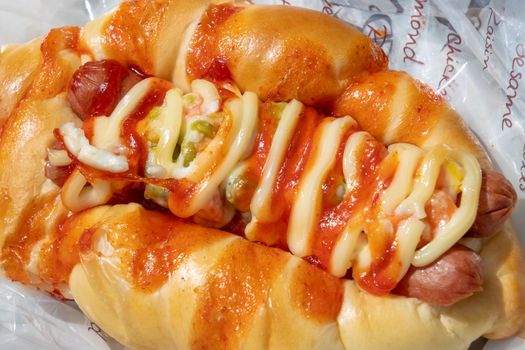 Baked hot dog served with pepperoni and sauce