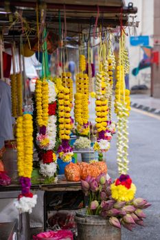 Flower chains and beautiful flower decoration sold on street market next to temple