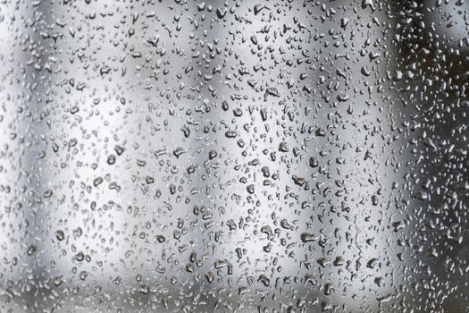 Water droplets on window during heavy monsoon rain falling