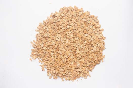 Cereal flakes for granola closeup. Flakes isolated on white background. Nutrition concept. Cereal flakes stock photo.