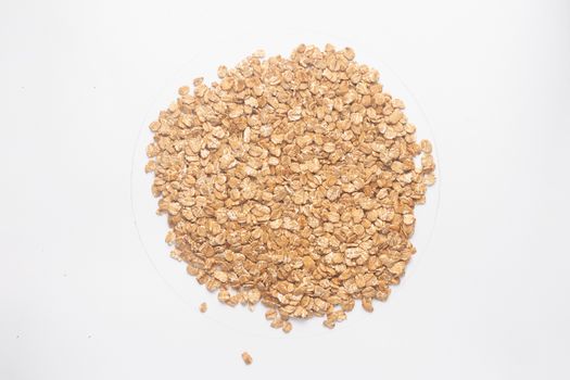 Cereal flakes for granola closeup. Flakes isolated on white background. Nutrition concept. Cereal flakes stock photo.