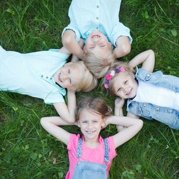 Little friends laying on grass in summer park