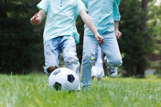 Happy children playing football in summer park