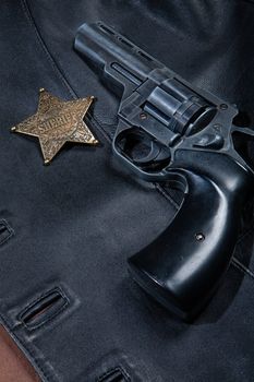 Star badge and revolver on a studio background