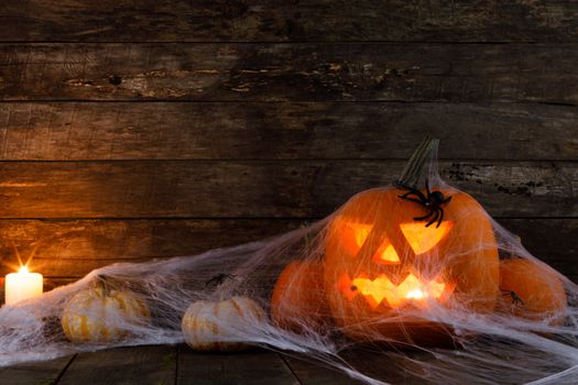 Jack O Lantern Halloween pumpkin, spiders on web and burning candles
