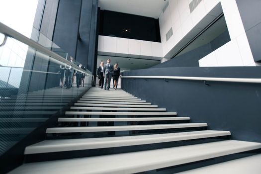 Group of Business people walking down stairs in office building