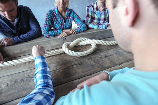 Business teamwork brainstorming planning meeting concept, people in casual clothes sitting around the table with rope node
