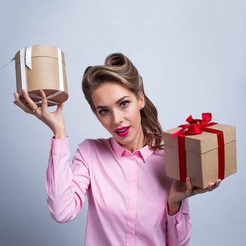 Beautiful young woman holding two holiday gifts