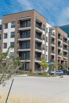 Row of apartment buildings near street in suburbs area of Dallas, Texas, USA. Multi-Storey flat unit, group housing complex condos for modern living style