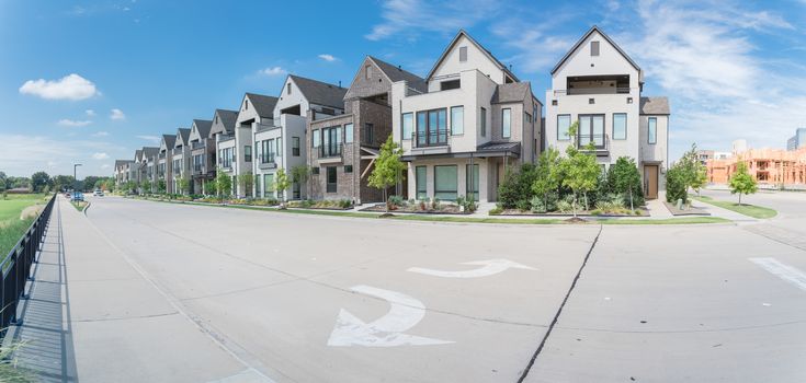 Panorama park side brand new row of three story single family houses in Richardson, North Dallas. Modern design of urban living residences with condominium building construction site in background