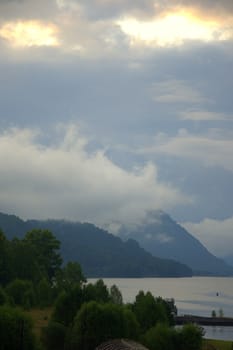 Morning fog over the waters of a mountain lake. Teletskoye Lake, Altai, Russia.