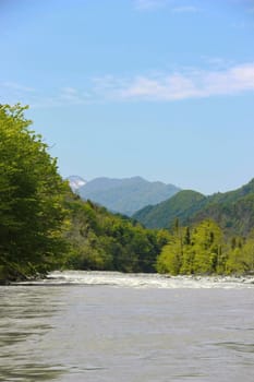 View on Acharistskali River and the snow-capped peaks of the mountains in the distance, view of the village of Makho, Georgia, Adjara, spring