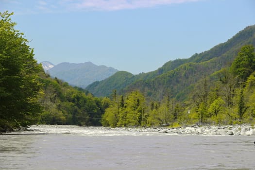 View on Acharistskali River and the snow-capped peaks of the mountains in the distance, view of the village of Makho, Georgia, Adjara, spring