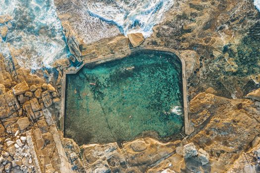 Swimmers have a refreshing swim in the coastal rock pool early morning.