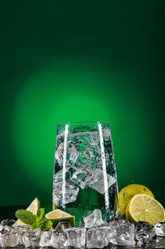 Glass of water, crystals of ice and lime