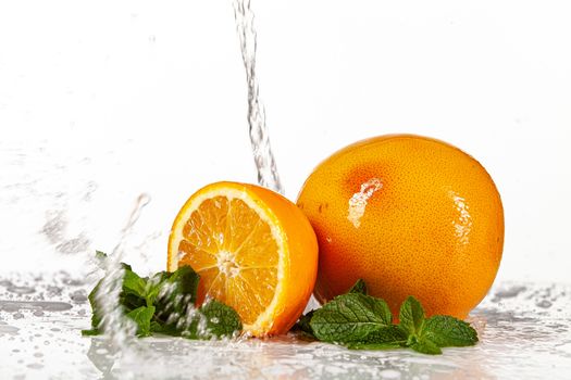 Grapefruit, orange and mint on a glass background