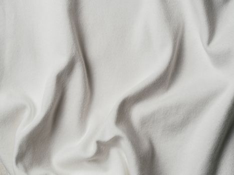White cotton fabric texture. Clothes cotton jersey background with folds
