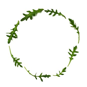 Pattern from arugula in round circle frame isolated. Circle shape in fresh green ruccola or arugula. Isolated on white with clipping path. Top view or flat lay. Can use for design vegan concept