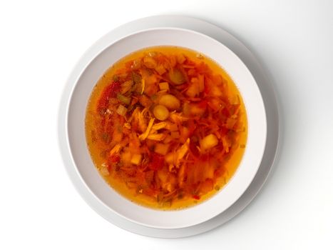 Bowl with chicken, beetroot and other vegetables soup. Perfect bright broth in italian minestrone style, isolated on white. Top view or flat lay.