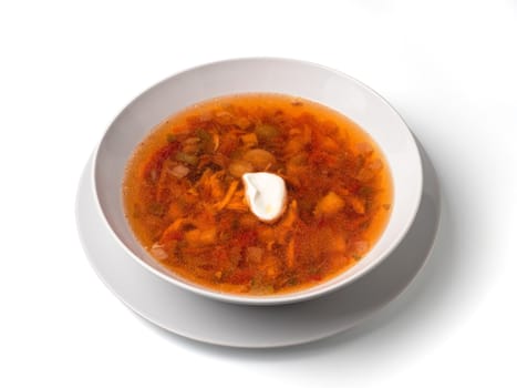 Soup with chicken meat, potatoes, carrot, tomatoes in bowl. Plate of orange red russian-style soup isolated on white. Isolated on white with clipping path.