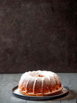 Fresh perfect muffin cake decorated icing sugar over table. Copy space for text. Ideas and recipes for breakfast or dessert. Vertical.