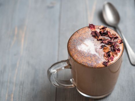 Trendy Coffee with edible glitter and dried rose petals. Cup of sparkly coffee or diamond cappuccino on gray table. Copy space for text